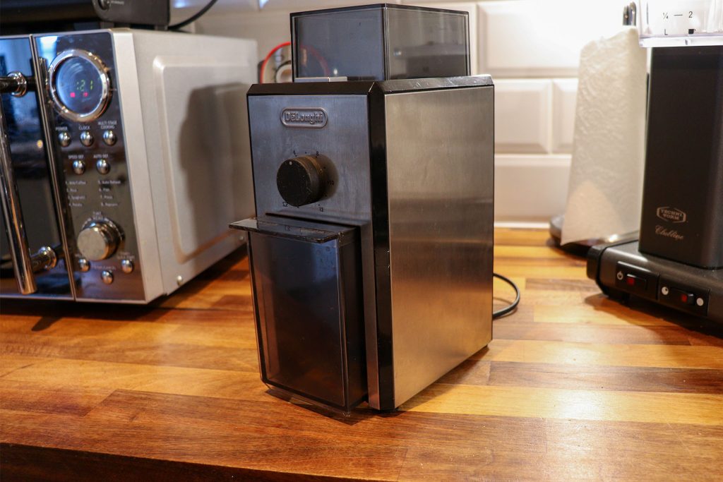 De’Longhi KG79 a konyhaasztalon teljes pompájában, ujjlenyomatokkal, karcokkal és repedésekkel