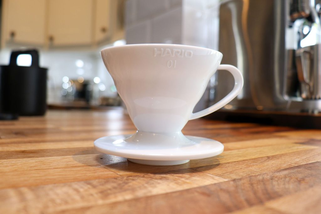 Közeli kép a fehér műanyag Hario V60 01 csepegtetőről a konyhapulton
