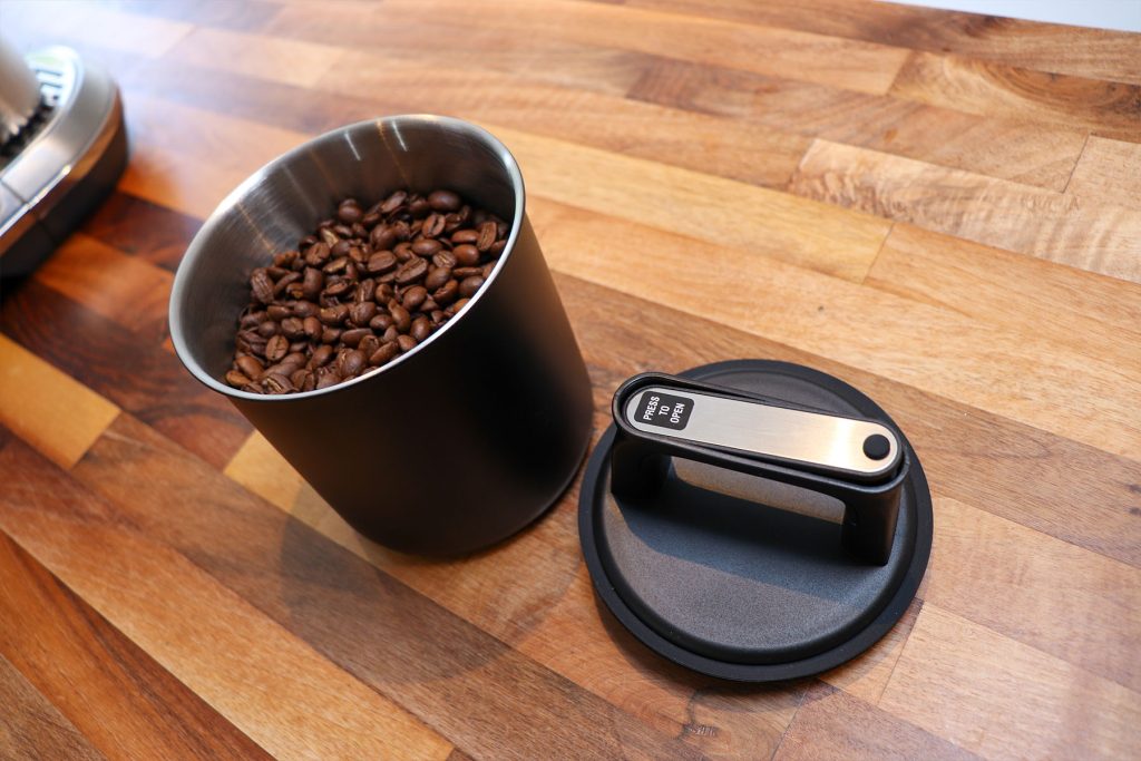 KC Kitchen & Co. coffee canister open with its lid removed and coffee beans inside